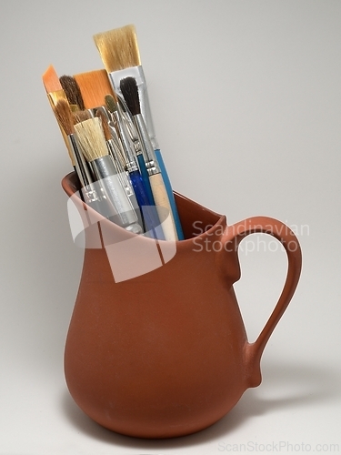 Image of artistic brushes in a ceramic pot