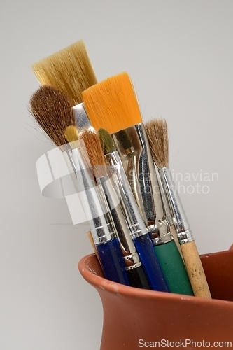 Image of artistic brushes in a ceramic pot 