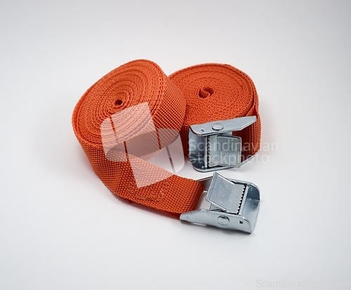 Image of two orange fastening straps on white