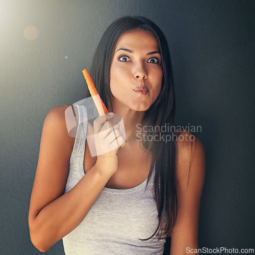 Image of Portrait, woman or eating carrot for healthy food in studio for vegan diet, meal or vegetables for lunch. Grey background, snack or vegetarian person with fresh, natural vitamins or organic produce