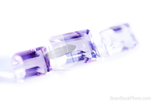 Image of Amethyst, rocks or gem in studio by white background for natural resource, jewelry and baguette style for luxury. Stone, purple crystal and closeup with shine, glow and brilliant cut for collection