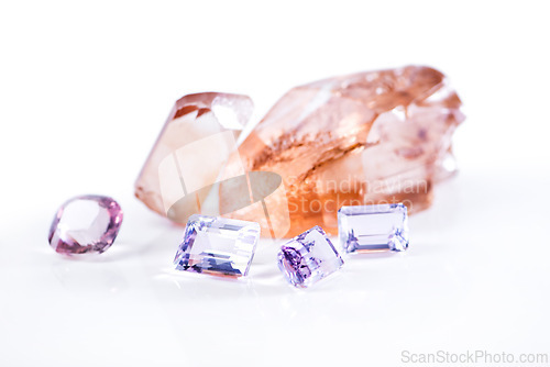 Image of Rock, amethyst and pink diamond in studio with isolated white background for natural resource, jewel and sparkle for luxury. Gemstone, crystal and reflection in closeup for shine, glow and mineral
