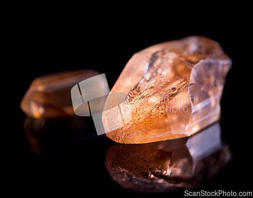 Image of Orange stone, jewel and crystal in studio with isolated black background for natural resource, shine and sparkle for luxury. gemstone, rock and reflection in closeup for citrine, glow and mineral