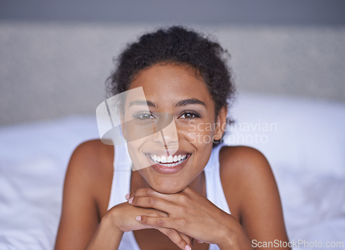 Image of Woman, happy and relax in bedroom in portrait, wellness and confident on morning vacation on home. Young lady, smile face and healthy on break on lazy weekend, pyjamas and calm on bed in apartment