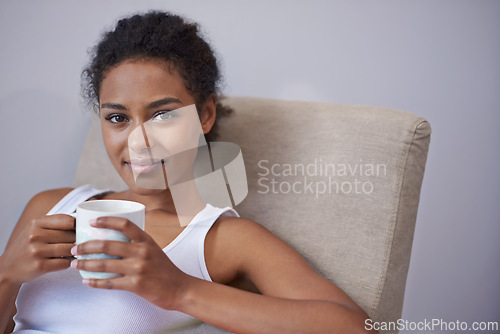 Image of Relax, portrait and calm woman with coffee on a chair for morning reflection, peace or insight in her home. Smile, face and female person with tea cup in a living room with rest, break or me time