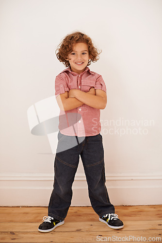 Image of Boy, child and confident in portrait for style, smile and proud for casual outfit or clothes in home. Male person, kid and cool fashion by wall background, happy and mockup space in living room