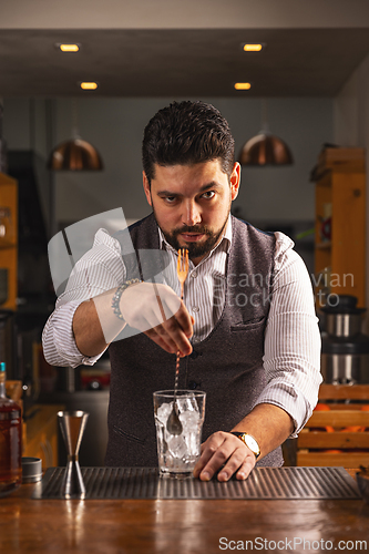 Image of Confident bartender crafting a cocktail