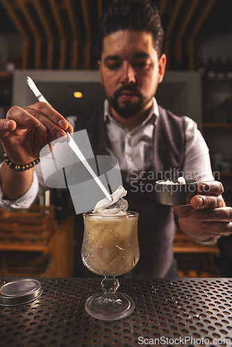 Image of Bartender garnishing craft cocktail with precision