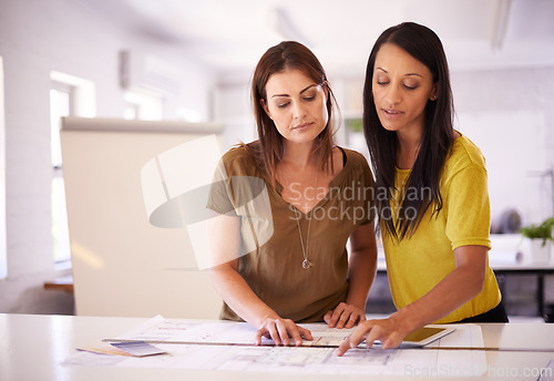 Image of Architect, women and blueprint in discussion at office with reading, planning and building development. People, team and architecture for property, expansion or documents for project in collaboration