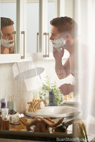 Image of Man, cream for shaving and grooming in bathroom, skincare and beauty with morning routine at sink. Skin health, cosmetic foam or soap for hygiene, dermatology and hair removal with facial at home