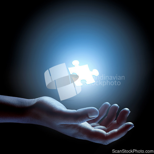 Image of Puzzle, piece and abstract solution in hand for problem solving, challenge and planning with strategy. Jigsaw, games or shape of idea to glow in light of dark and search for innovation in business