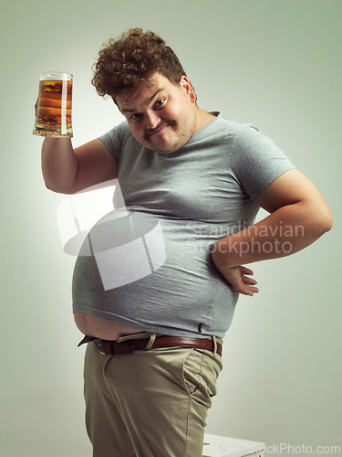 Image of Obese, weight gain and beer for man in studio with alcohol for unhealthy habit, plus size and humor. Overweight person with glass in hand and fat stomach for cheers and comedy for comic expression