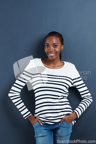 Image of Black woman, happy and portrait in studio with confidence and trendy fashion by blue background. African model, positive or face with hands in pocket, calm or pride in funky jeans for gen z aesthetic