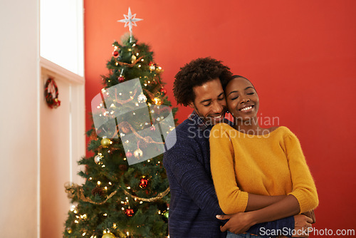 Image of Couple, Christmas tree and festive holiday in house with happiness fr vacation celebration, gifts or bonding. Man, woman and smile with lighting decoration for winter season event, together or lounge