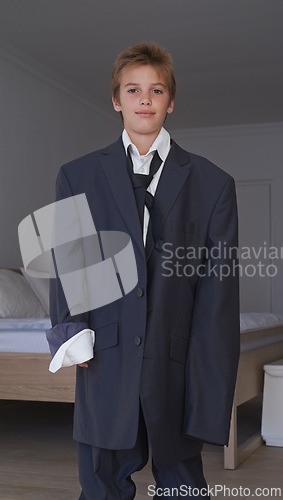 Image of Portrait, boy and pretend suit on male person, oversized business clothes for dream job on child. Dress up, kid and happy smile on career day for school, costume and standing in home bedroom