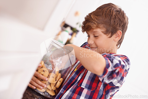 Image of Cookie, jar and child in home eating from glass, container or happy with sweets in kitchen. House, snack and kid craving a taste of sugar and excited for biscuit and unhealthy food with energy