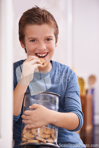 Image of Eating, cookies and portrait of child in home with glass, container or happy with jar of sweets in kitchen. House, snack and craving taste of sugar from addiction to unhealthy food or biscuit