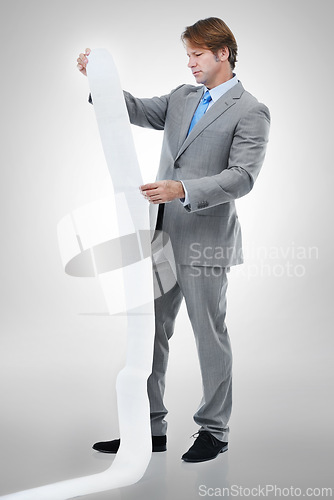 Image of Businessman, documents and receipt with finance for bills, expenses or list on a gray studio background. Man or employee checking financial paperwork or report for audit or budget planning on mockup