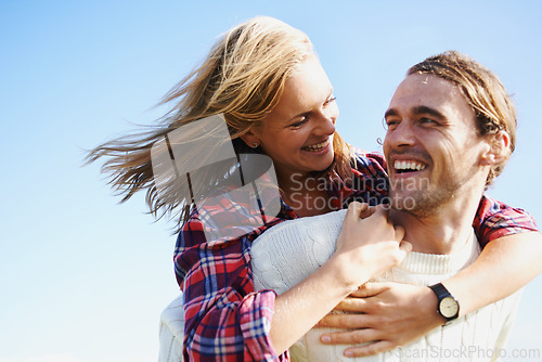 Image of Happy couple, travel and bonding together in nature, piggyback and romantic getaway on holiday by blue sky. Man, woman and love on vacation on weekend break, joy and adventure in outdoor on honeymoon