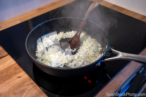 Image of onions preparing on cooking pan 