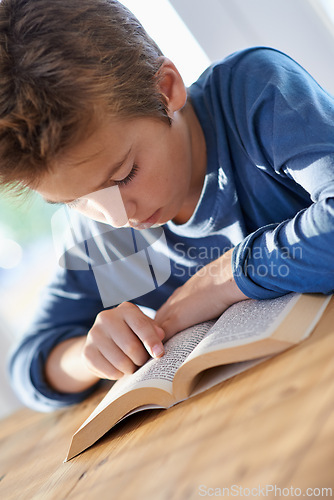 Image of Home, boy and kid with reading textbook for homework with learning for child development, education and growth. Homeschool, notes and study with revision for exams or test and school project