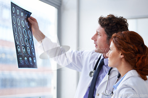 Image of Doctors, brain scan and check results at hospital with teamwork, review and healthcare by window. Neurology, man and woman with xray reading for wellness, ideas and decision with document in clinic