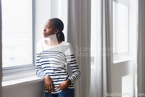 Image of Woman, serious and thinking by window in new home with confidence for real estate investment and mortgage. African homeowner, thoughtful and relax with future house ideas or relocation in living room
