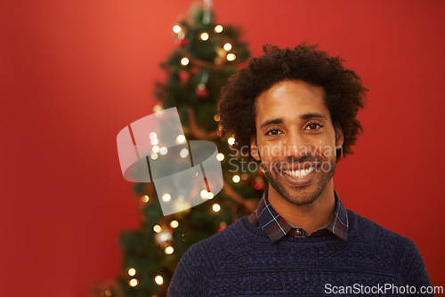 Image of Man, portrait and smile at Christmas holiday for relax weekend for festive season, red background or mockup space. Male person, face and happy or ornament decoration or present, giving or celebration