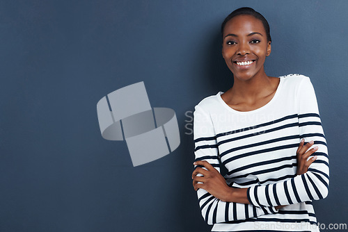 Image of Black woman, happy and portrait in studio in fashion career and arms crossed for confident professional. African designer, face and smile for creativity as tailor by blue background and pride in job