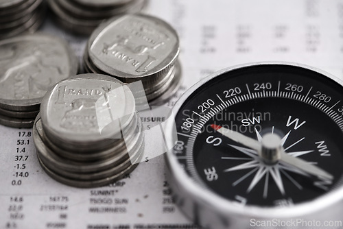 Image of Coins, compass and business section of newspaper for exchange rate and direction on stock market for investor. Information, money and illustration of forex trading and financial indicators on paper