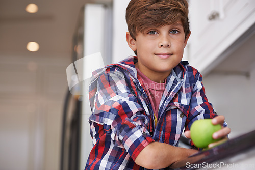 Image of Portrait, apple and boy kid in kitchen of home with food as diet, health or nutrition for development. Fruit, wellness and organic snack with confident teen child in apartment for growth or hunger