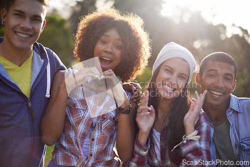 Image of Portrait, smile and diverse friends in nature, outdoors or garden with excited expression. Social, joy or happy with hand heart emoji from group of student, summer and sunset with lens flare outside