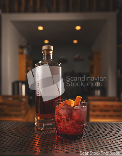 Image of Artisanal cocktail on bar counter with whiskey bottle