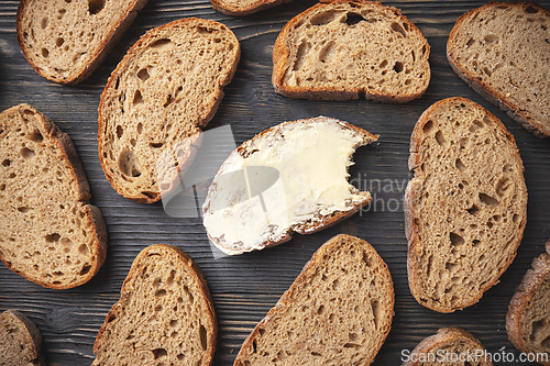 Image of Sliced whole grain bread with a buttered piece