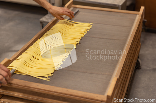 Image of Fresh pasta drying on wooden rack