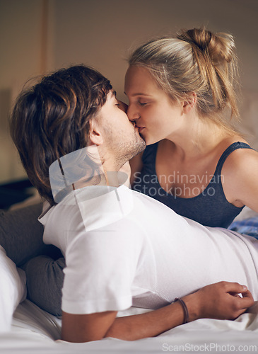 Image of Love, kiss and couple on a bed with care, trust and support, security and bonding in their home together. Morning, romance and people embrace in a bedroom with intimacy, moment or fun in their house