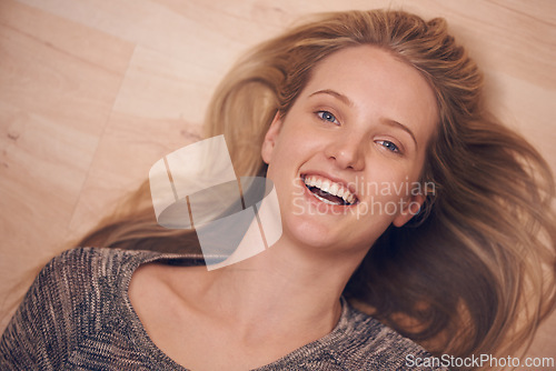 Image of Happy, portrait and woman on a floor with confidence, positive attitude or feel good mood from above. Face, smile and female person relax in a living room on day off, weekend or vacation in her home