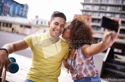 Image of Selfie, kiss and couple with skateboard in city for exercise, training and sports hobby in town. Skate park, fashion and man and woman on smartphone for social media, networking and online picture