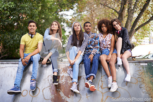 Image of Serious, portrait and group of friends at skatepark for bonding, skating and sitting together. Gen z, diversity and young people with skateboard for practice or training for competition together.