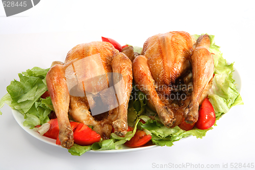 Image of Two roast chickens on a bed of salad