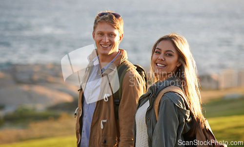 Image of Love, portrait and happy couple on hike with ocean, sunset for tropical holiday adventure, relax and bonding together. Smile, man and woman on romantic date with beach, nature and grass on vacation