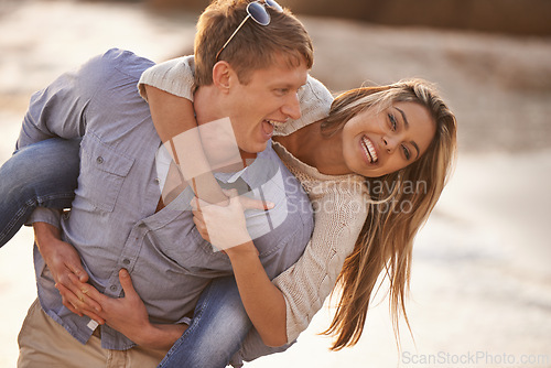 Image of Couple, piggyback and laugh in portrait at beach, ocean waves and fun for romance in relationship. People, carry game and playful in marriage, sea and travel together on vacation or holiday for date