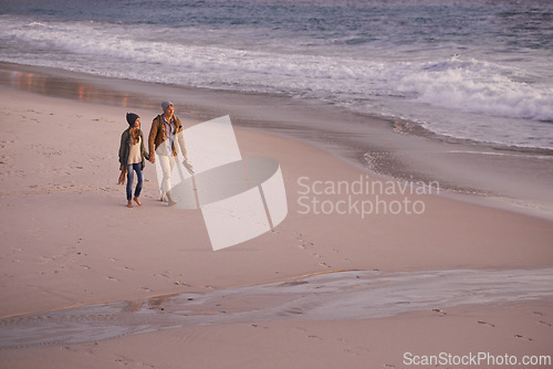 Image of Couple, holding hands and love for walking on shore, ocean waves and peace for romance in relationship. People, beach and security in marriage, sea and travel together on vacation or holiday for date