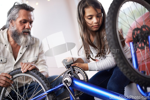 Image of Father, child and bicycle for fixing chain as maintenance in garage for bonding together, transportation or teamwork. Mature man, daughter and equipment for bike repair or gear help, wheel or tyre