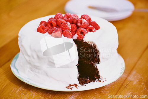 Image of Chocolate, dessert and blackforest cake for bakery, raspberries and sweet snack for eating. Fruit, icing and plate for display on table in restaurant, creamy and baked confection with berries