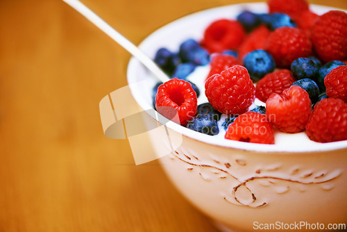 Image of Closeup, berries and bowl with yogurt, raspberry and blueberry for organic snack. Food, cuisine and breakfast for health, wellness and diet for morning nutrition and antioxidant wellbeing in studio