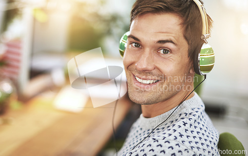 Image of Portrait, office and headphone for happy male worker, music or podcast for entertainment. Smile, employee and listening or working at workspace in Holland, startup or entrepreneur for tech company