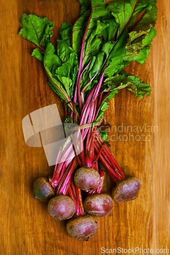 Image of Beetroot, closeup and counter for nutrition, wellness or organic diet on wood countertop. Vegetable, health or produce for eating, gourmet and meal or cuisine with vitamins or fibre for weight loss