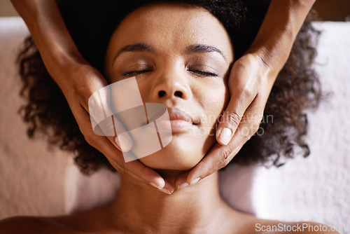 Image of Woman, spa and massage on face with hands and care for facial, wellness and beauty treatment on bed. Above, towel and calm african female person with skincare and relax at a hotel with skin glow