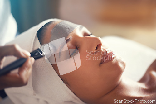 Image of Facial, mask and cosmetic treatment for woman in spa for relax, wellness and beauty for break and skincare. Young person with eyes closed and towel on head with product on face for hygiene and care